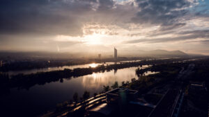 Donauinsel Vienna sunset view over Danube River with golden hour lighting and city silhouette.