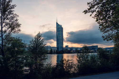 Donauinsel Wien evening illumination with city lights reflecting on Danube River water surface.