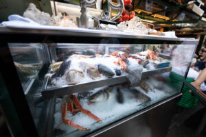 Frischfischverkäufer am Naschmarkt mit Tagesfang auf Eis.