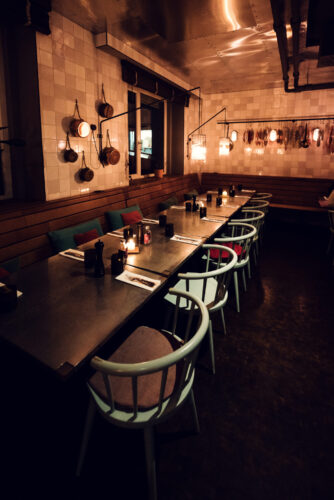 Softly lit dining room at Ribelli during evening hours.