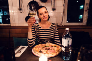 Adriana enjoying authentic Neapolitan pizza at Ribelli's stylish dining space.