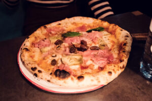 Wood-fired Neapolitan pizza at Ribelli with charred crust and fresh toppings.