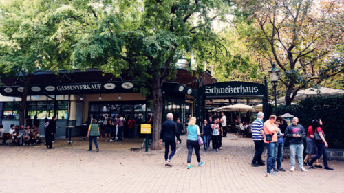Schweizerhaus's main entrance during peak summer season in Vienna's Prater.