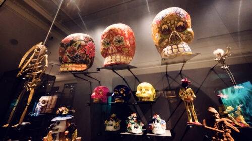 Vibrant collection of Mexican Calaveras (decorative skulls) at Weltmuseum Vienna.