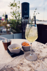 Présentation d'un cocktail à l'Atmosphere Rooftop Bar avec la ville de Vienne en toile de fond.