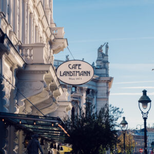 Café Landtmann's Neo-Baroque facade on Universitätsring 4, with its original 1873 architectural details and outdoor seating area facing the Burgtheater.