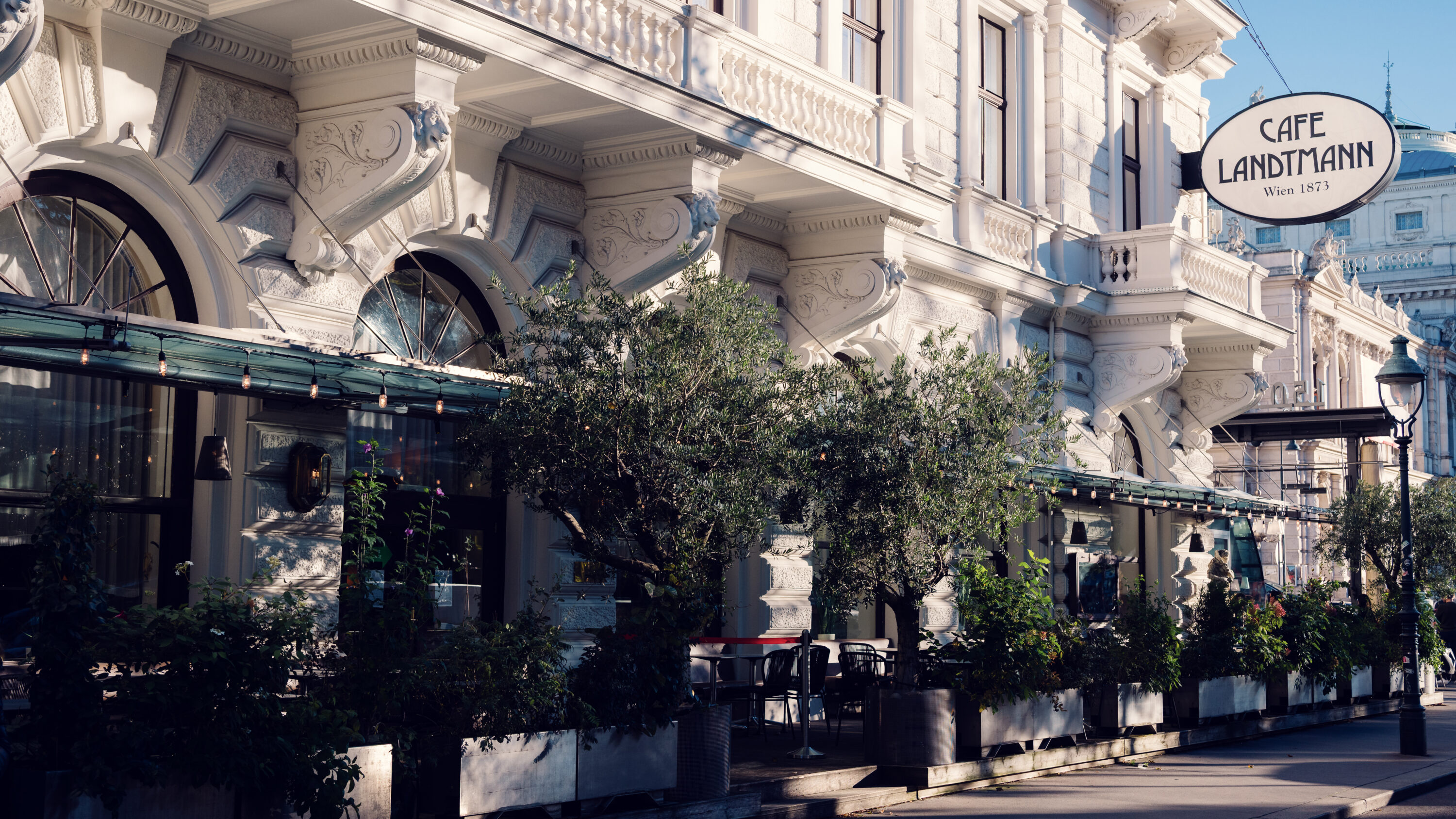 Exterior view of Café Landtmann (Café Landtmann Wien) with its iconic Ringstrasse facade and outdoor seating area.