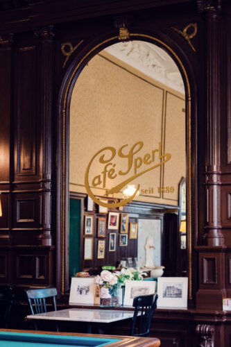 Ornate gilt-framed mirror at Café Sperl reflecting historic coffee house atmosphere through original 1880s glass.