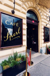 Elegant entrance archway of Café Sperl featuring original brass lettering and historic door details.