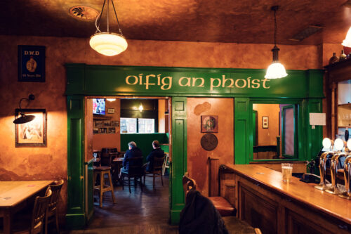 Insegna gaelica 'Oifig an Phoist' sulla parete del Flanagans Irish Pub di Vienna.