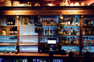 Collezione di bottiglie di whiskey esposta dietro il bancone del Flanagans Irish Pub di Vienna.
