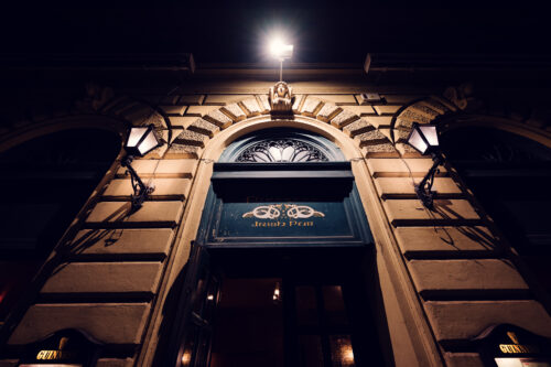 Evening scene at Flanagan's entrance, featuring iconic Irish pub signage and traditional lanterns.