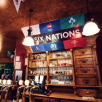 Sports fans watching a match on multiple screens at Flanagans Irish Pub Vienna.