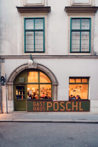 Illuminazione calda serale all'ingresso del Gasthaus Pöschl a Vienna.