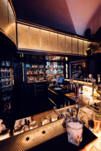 Main bar area at Kleinod Vienna showing marble countertop and classic cocktail setup.