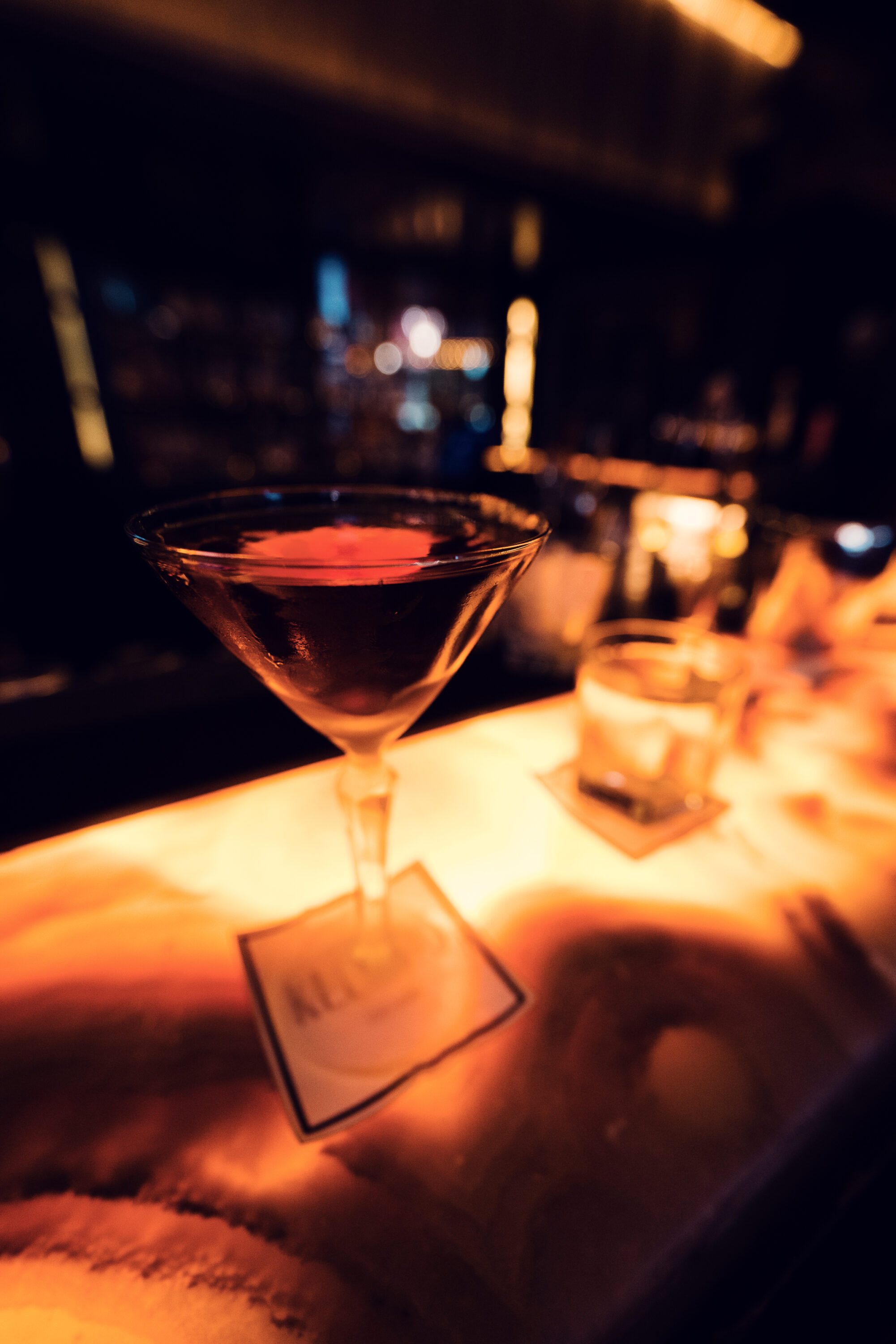 Signature cocktail preparation at Kleinod Vienna's marble bar counter.
