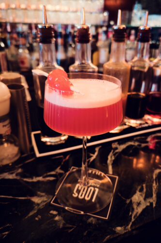Artisanal cocktail crafting at Loos Bar, where traditional techniques honor the historic setting.