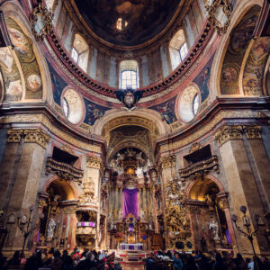 Prachtvolles Inneres der Peterskirche in Wien mit aufwendigen Marmorsäulen, filigranen Kanzelschnitzereien und dem berühmten ovalen Grundriss der barocken Kirchenarchitektur.