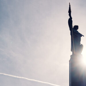 Close-up of the golden-helmeted Soviet soldier statue at Schwarzenbergplatz Vienna bathed in sunset light.