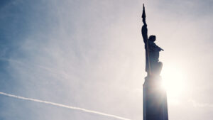 Primo piano della statua del soldato sovietico con elmo dorato sulla Schwarzenbergplatz a Vienna nella luce del tramonto.