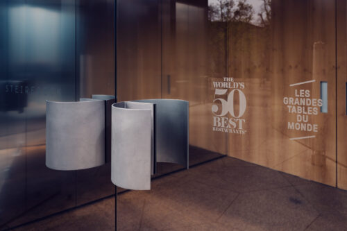 Awards display at Steirereck entrance with World's 50 Best Restaurants and Les Grandes Tables du Monde signs.