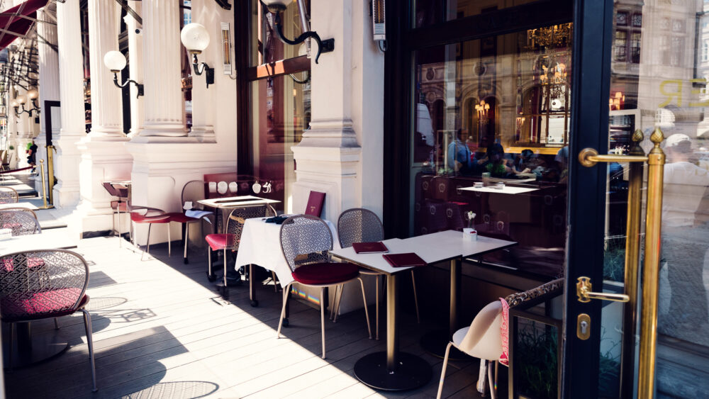 Charming outdoor terrace of Café Sacher Vienna with traditional café furniture and views of the historic city center.