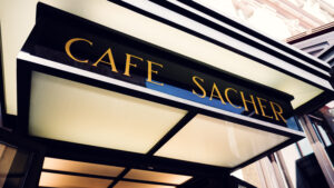 Close-up of the original Café Sacher sign with golden lettering.