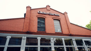 Entrance to Gleis//Garten Vienna with large windows and original railway architecture.