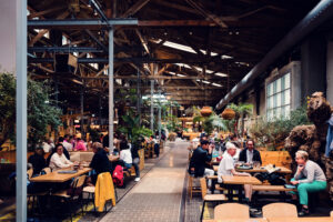 Industrial interior of Gleis//Garten Vienna with exposed brick and high ceilings.