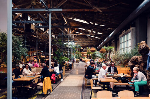Industrial interior of Gleis//Garten Vienna with exposed brick and high ceilings.