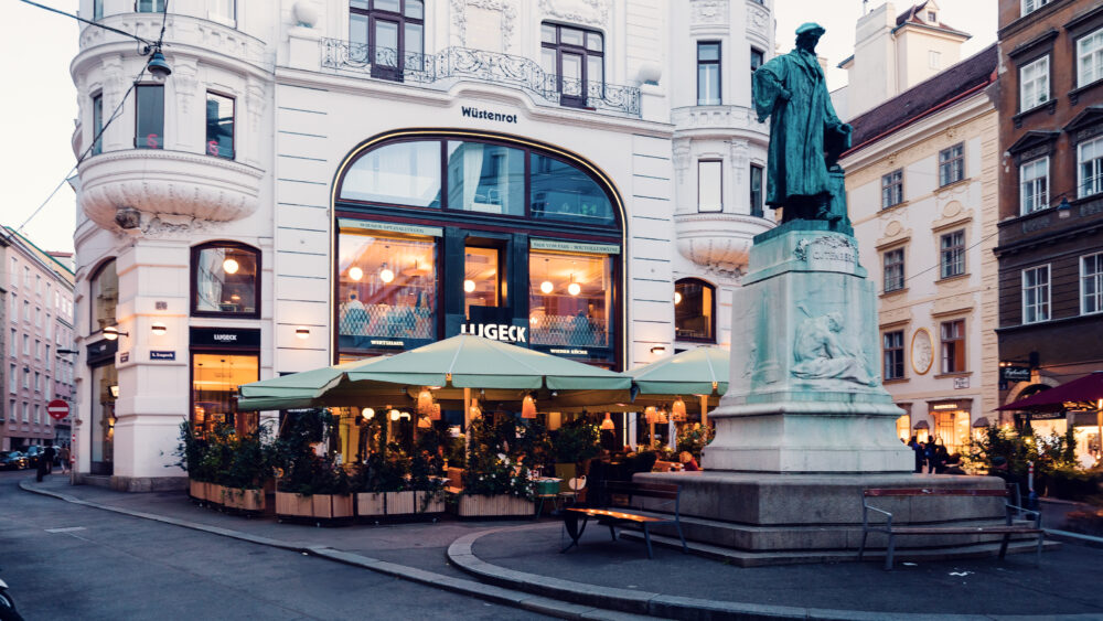 Outside view of Lugeck Vienna restaurant building, historic Viennese architecture with traditional storefront design and outdoor seating area in Innere Stadt.