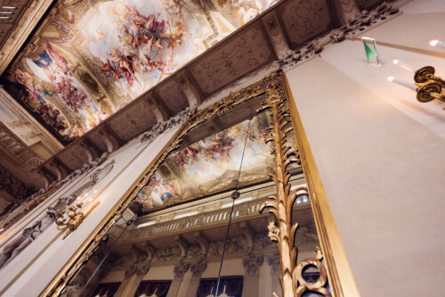 Vienna Kinsky Palace interior baroque grand salon with ornamental ceiling frescoes crystal lighting and Habsburg era palace decorative arts.