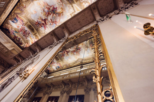 Grand salon du Palais Kinsky à Vienne avec fresques au plafond, lustres en cristal et arts décoratifs.