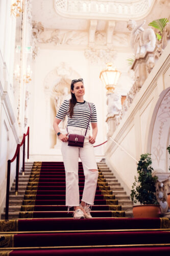 Adriana standing at Palais Kinsky Vienna baroque palace steps.