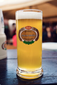 A glass of Salm Bräu beer with the brewery logo on the table.