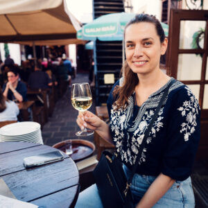 Adriana cheering with wine glass at Wiener Salm Bräu Vienna.