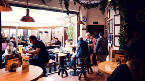 Dining room with wooden tables and bench seating inside Salm Bräu.