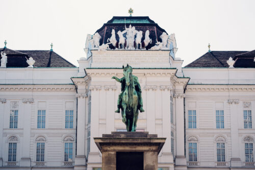 Josefsplatz courtyard surrounded by Austrian National Library Prunksaal entrance and 18th-century Imperial Hofburg architecture.