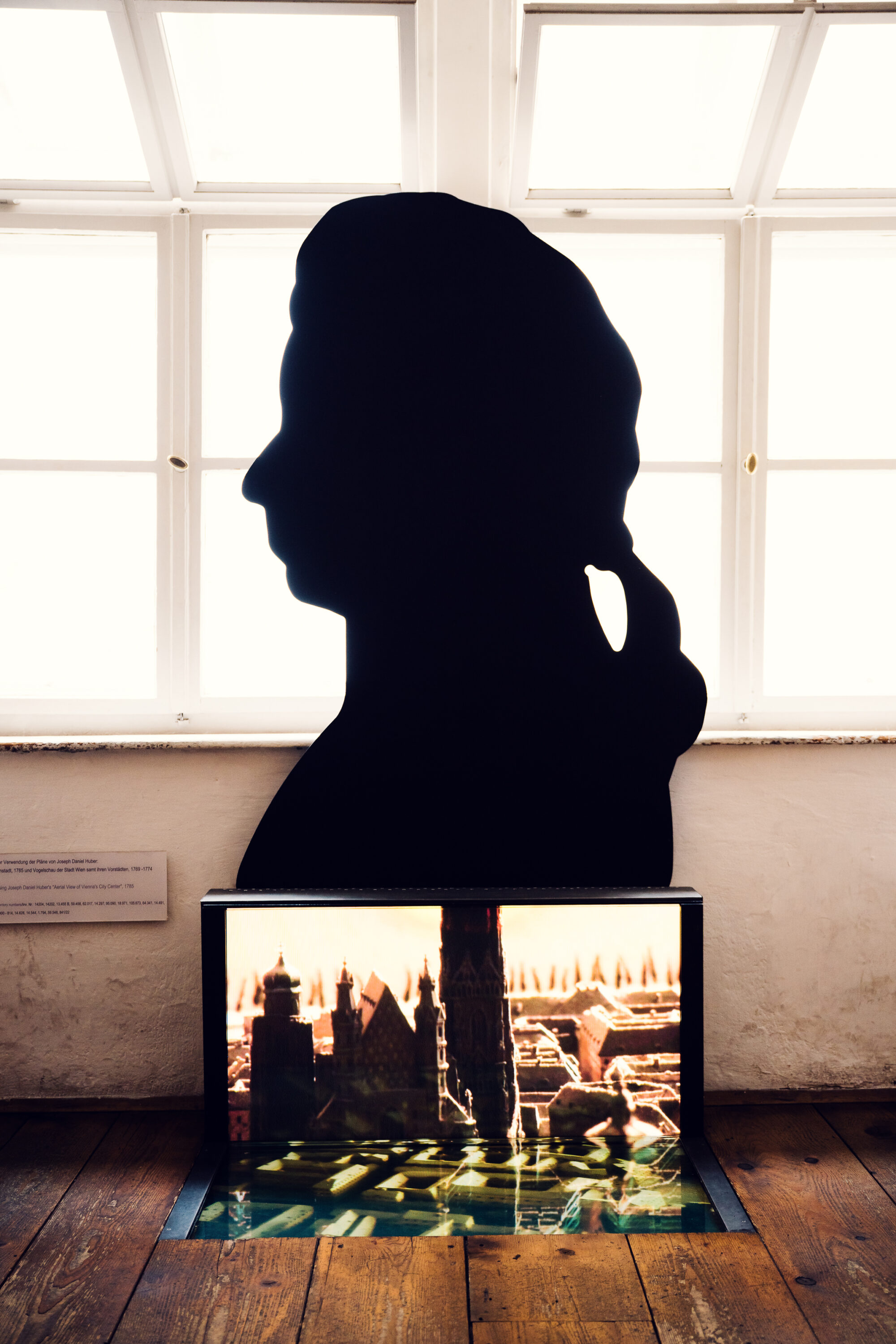 Mozart silhouette cutout in front of a Vienna cityscape display at Mozarthaus.
