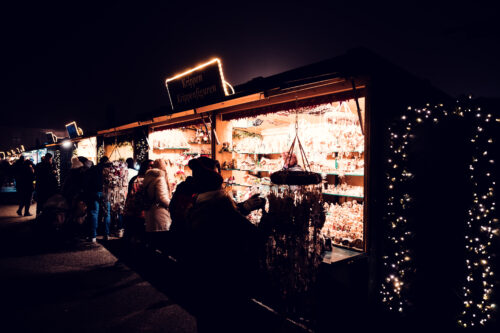 Visitors browsing Christmas market stalls at Schönbrunn Palace (Schloss Schönbrunn) forecourt.