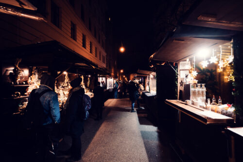 Illuminated Christmas market vendors along narrow Spittelberg alleyways.