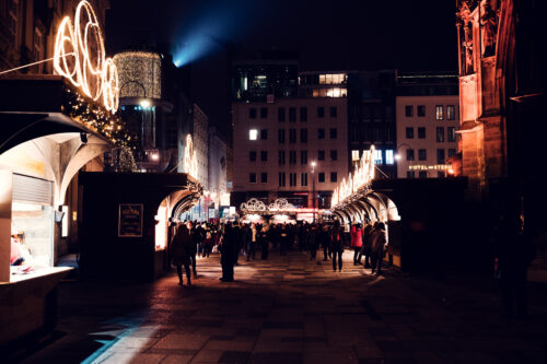 Crowd of visitors at Christmas market stalls on Stephansplatz in front of St. Stephen's Cathedral (Stephansdom).