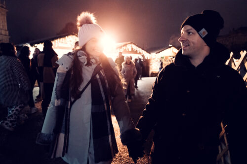 Adriana et Mario traversent main dans la main le marché de Noël, le sourire aux lèvres.