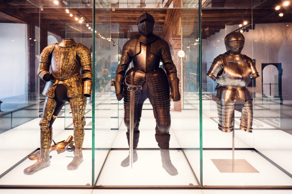 Tre armature medievali in teche di vetro nel museo della fortezza.