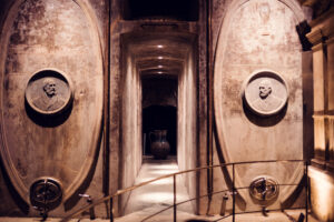 Historic wine storage tanks with portrait medallions flanking a narrow passageway in the Schlumberger underground vaults.