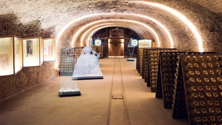 Vaulted cellar hall with information displays, riddling racks, and an ice sculpture at Schlumberger Kellerwelten.