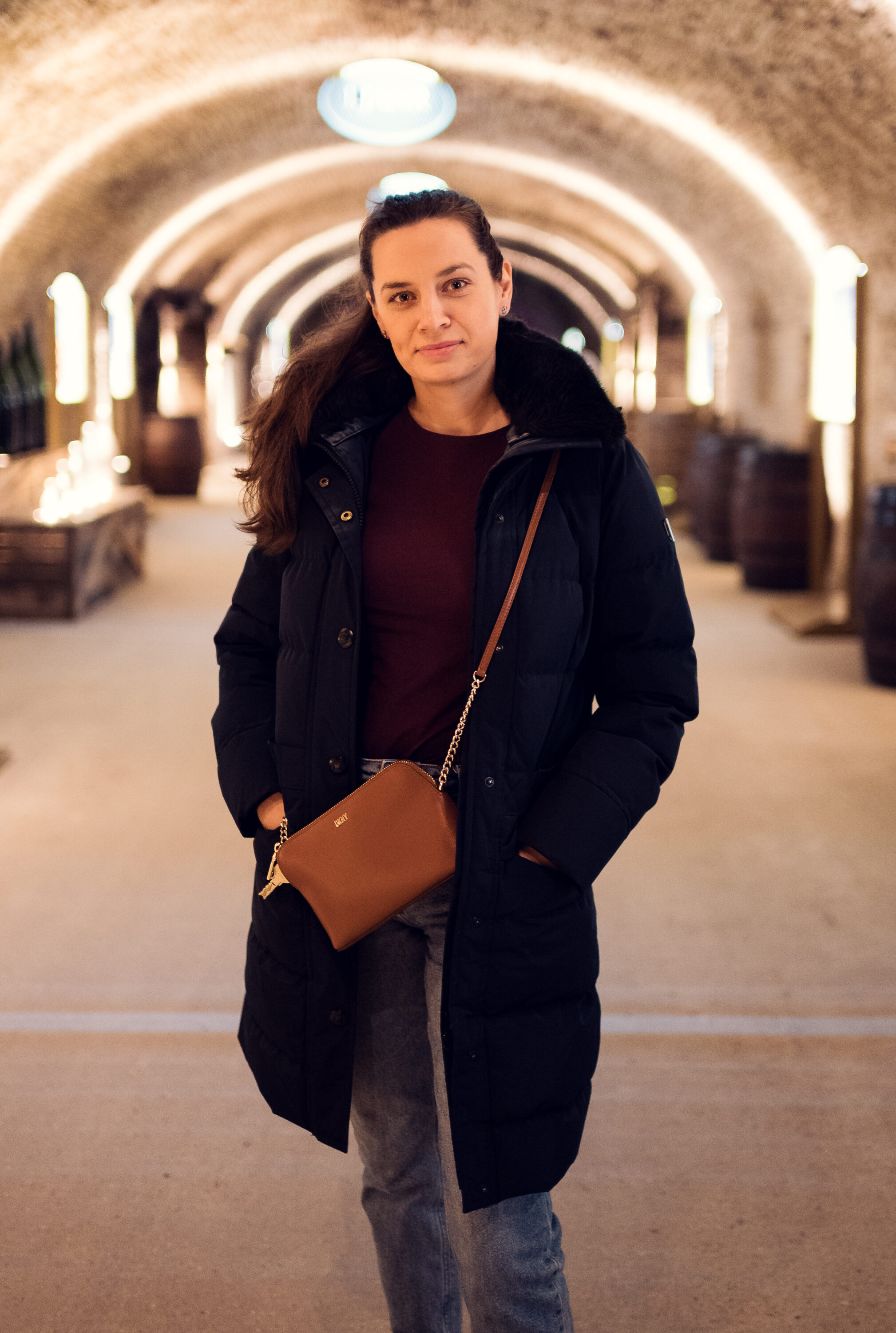 Adriana standing in the vaulted Schlumberger cellar corridor during a guided tour.