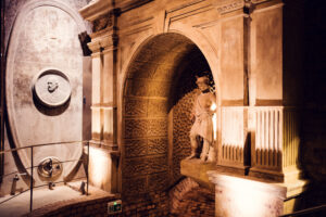 Cathedral-shaped DOM-Keller portal with a classical statue and relief medallion inside the Schlumberger cellars.