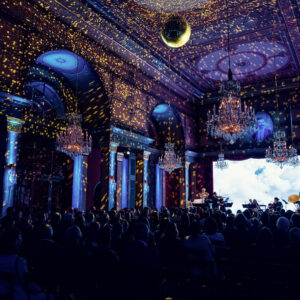 Sala Strauss illuminata di blu con effetti di luce dorata durante una serata di concerto.