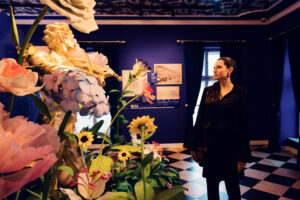 Adriana admiring oversized floral art installation at House of Strauss.